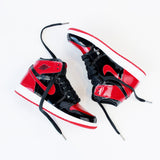 Looped Laces Black waxed shoelaces in Air Jordan 1 High Patent Bred sneakers on white background