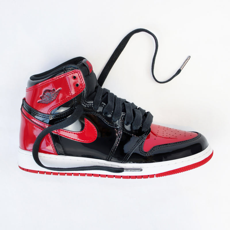 Looped Laces Black waxed shoelaces in Air Jordan 1 High Patent Bred sneaker on white background