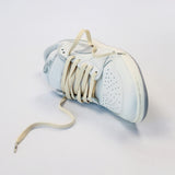 Looped Laces Sail off-white aged cream flat shoelaces in Air Jordan 1 Low Neutral Grey sneaker on white background with close up on laces