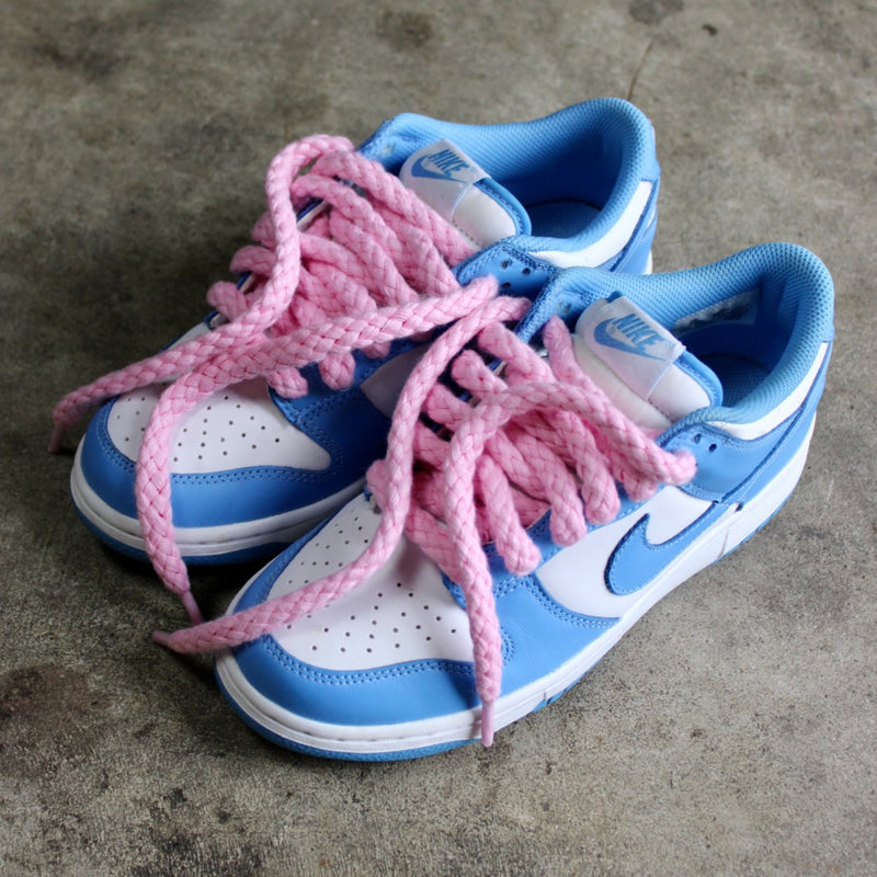 Looped Laces Light Pink Jumbo Rope Shoelaces tied in a pair of Nike Dunk UNC Blue sneakers on cement