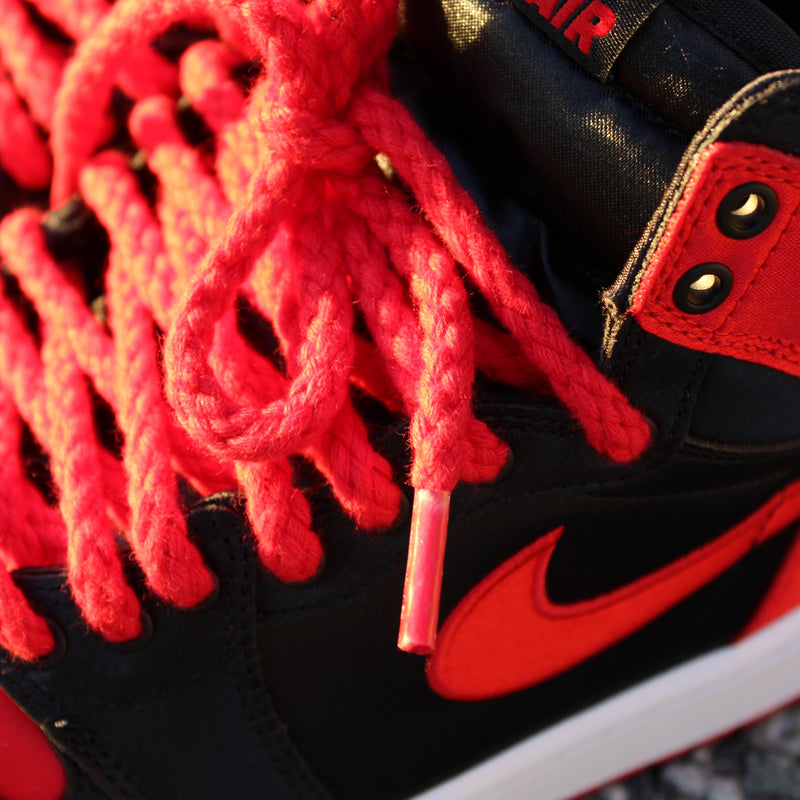 Looped Laces Red Rope Shoelaces tied in a pair of Air Jordan 1 High Satin Bred Toe sneaker closeup