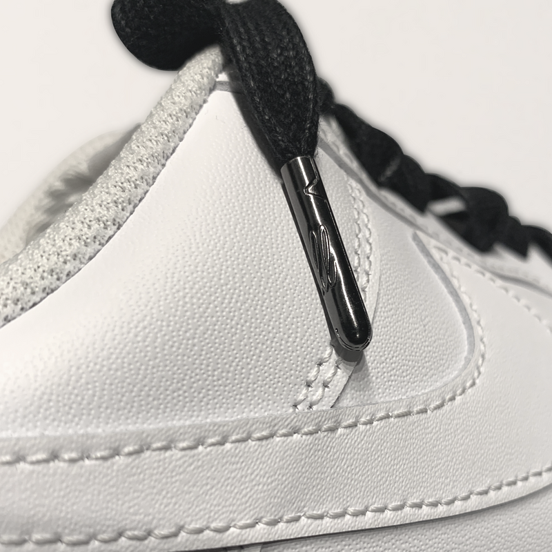 Looped Laces black waxed shoelaces tied in white Nike Air Force 1 sneaker with close-up on LL embossed aglet