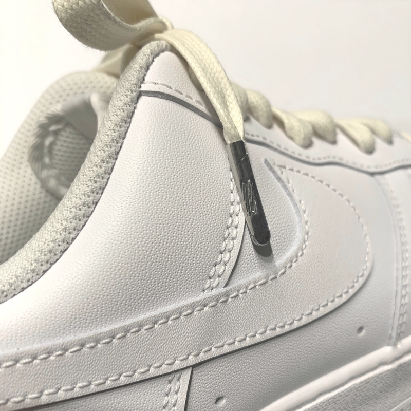 Looped Laces cream waxed shoelaces tied in white Nike Air Force 1 sneaker with close-up on LL embossed aglet