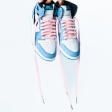 Looped Laces light pink waxed shoelaces in Air Jordan 1 High University Blue sneaker being held while laces are hanging